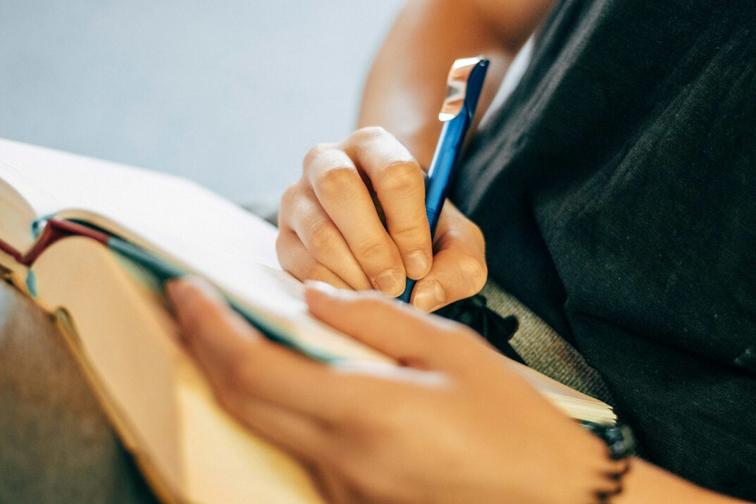 person writing in journal