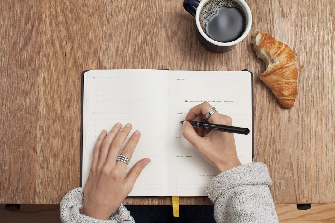 person writing in journal