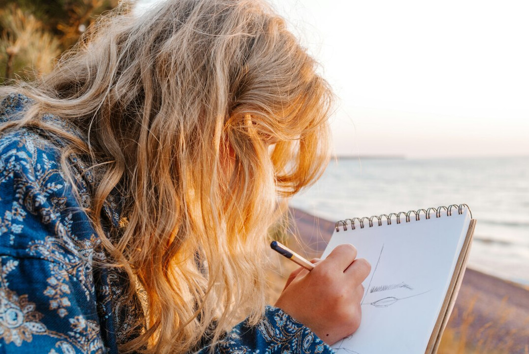 woman writing in journal outdoors